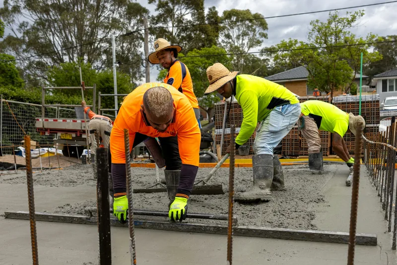 Crew leveling fresh concrete on a job site